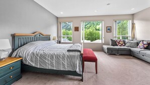 Une chambre à coucher avec un lit, une table de chevet, un banc et un canapé.