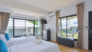 A hotel room with two beds, a TV, a mini-fridge, and a view of the outdoors. - Peace Garden Resort Koh Samui (Koh Samui)