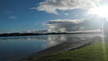 A calm lake with a clear sky and sunlight reflecting on the water.