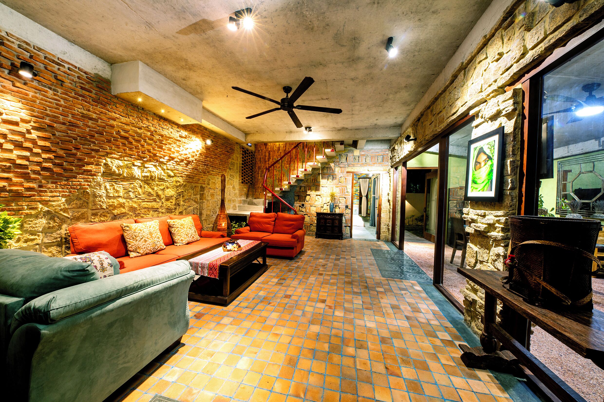 A cozy living area with a brick wall, a ceiling fan, and a tiled floor.