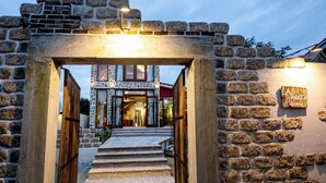 A stone archway leading to a building with a red roof and a sign that reads "Rocca". - La Rocca An Bang beach (Da Nang)