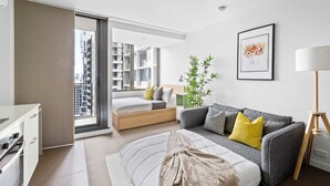 A modern apartment with a bed, sofa, and a dining area. - Cozy Studio Near Southern Cross with City Views (Melbourne)