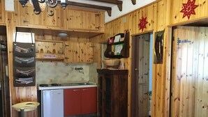 Eine rustikale Küche mit Holzausstattung, einem Spülbecken und einem Herd.