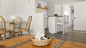 Un comedor con una mesa de madera, sillas y una cesta tejida con un adorno.