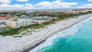 A coastal cityscape with a beachfront hotel, buildings, and a clear view of the ocean. - Sandcastles 2BR/2BA Cocoa Beach Ocean Views! Heated Pool! (Cocoa Beach)