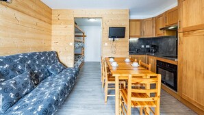 Een kleine keuken met houten kastjes en een inbouwfornuis.