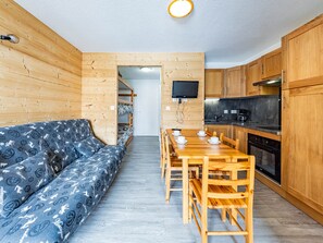 Kompakti keittiö, jossa on puukalusteet ja sisäänrakennettu liesi.
