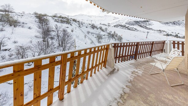 A balcony with a wooden railing overlooking a snowy mountain landscape. - 8-person apt at the slopes, south-facing balcony, central location (Saint-François-Longchamp)