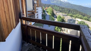 Un balcon donnant sur une chaîne de montagnes et une zone résidentielle.
