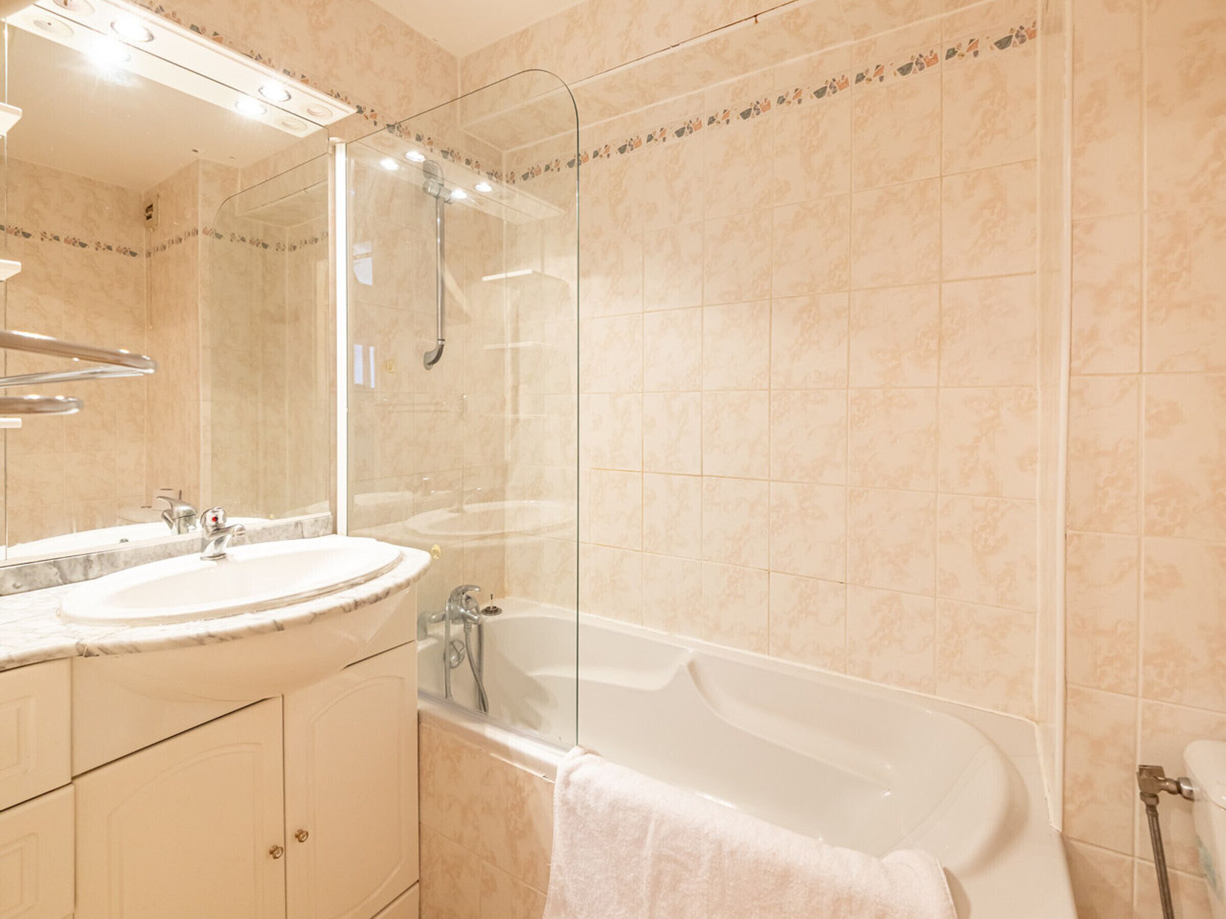 A modern bathroom with a glass-enclosed shower, a standalone bathtub, and a vanity with a sink and mirror.