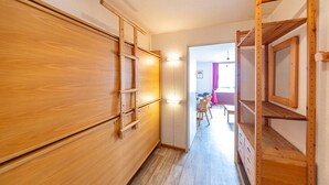 Un pasillo con paredes y escalera de madera.