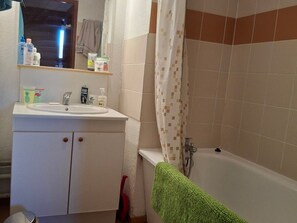 A bathroom with a white sink, mirror, and tiled walls. - 6-person apartment on the slopes in St-François-Longchamp (Saint-François-Longchamp)