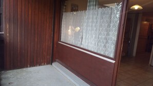 Puinen ovi, jossa on huurrettu lasi-ikkuna, laatoitettu lattia ja näkyvissä oleva käytävä, jonka katossa on valaisin.