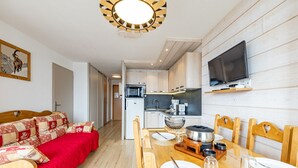 Ein kompakter Wohnbereich mit Küchenzeile, Essbereich und Schlafzimmer.