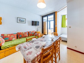 A cozy living room with a sofa, a dining table, and a TV. - Bright studio at the foot of slopes, near chairlift, balcony in Saint-François-Longchamp (Saint-François-Longchamp)