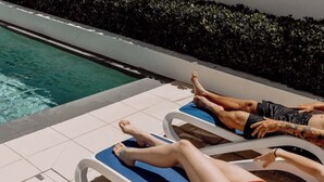 A poolside area with lounge chairs and a pool.
