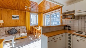 A cozy, well-lit kitchen with wooden cabinets and a dining area featuring a wooden table and chairs.