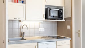 A compact kitchen with a sink, a microwave, and a dishwasher.