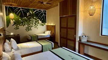 A hotel room with two beds, a wooden ceiling, a wall mural, a traditional woven lamp, and a window with a view.