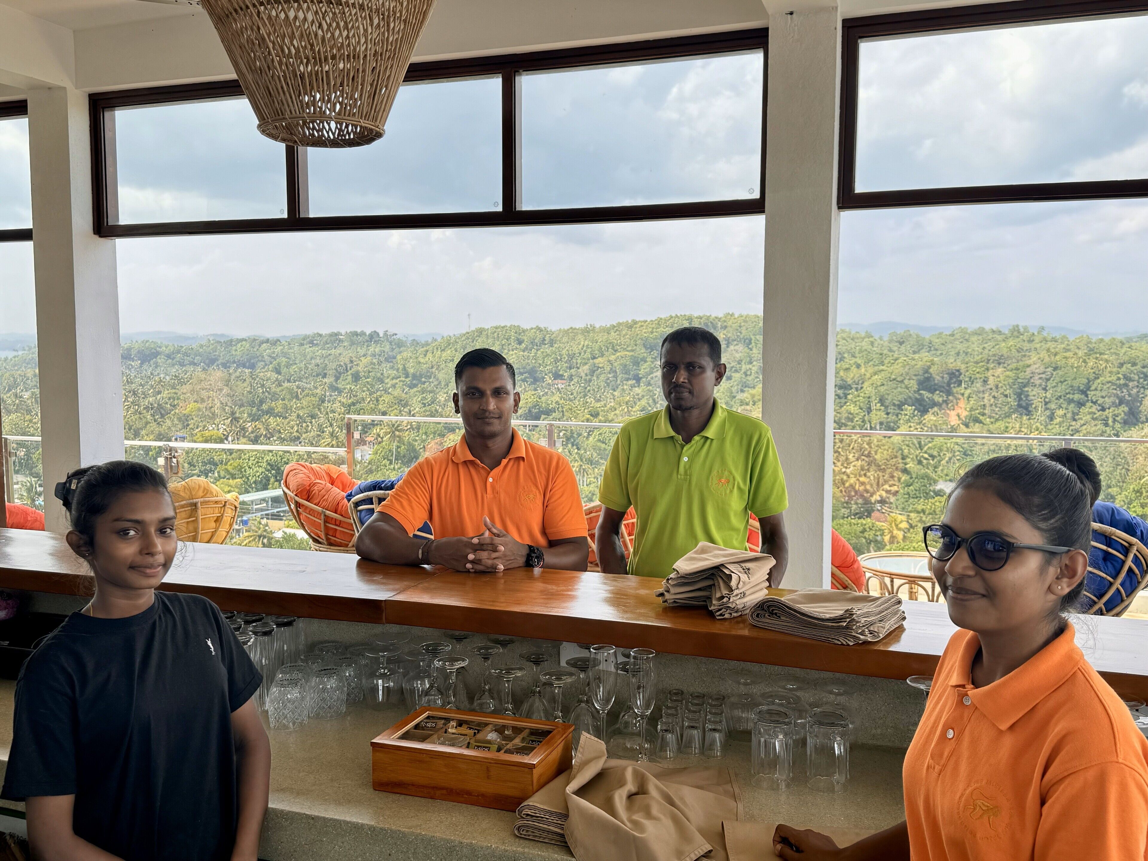 A bar area with a view of a forested landscape through large windows.