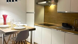A modern kitchen with white cabinets, a wooden countertop, and a stainless steel sink. - Luxury Apartments Collection - The Sand Suite (Passoscuro)