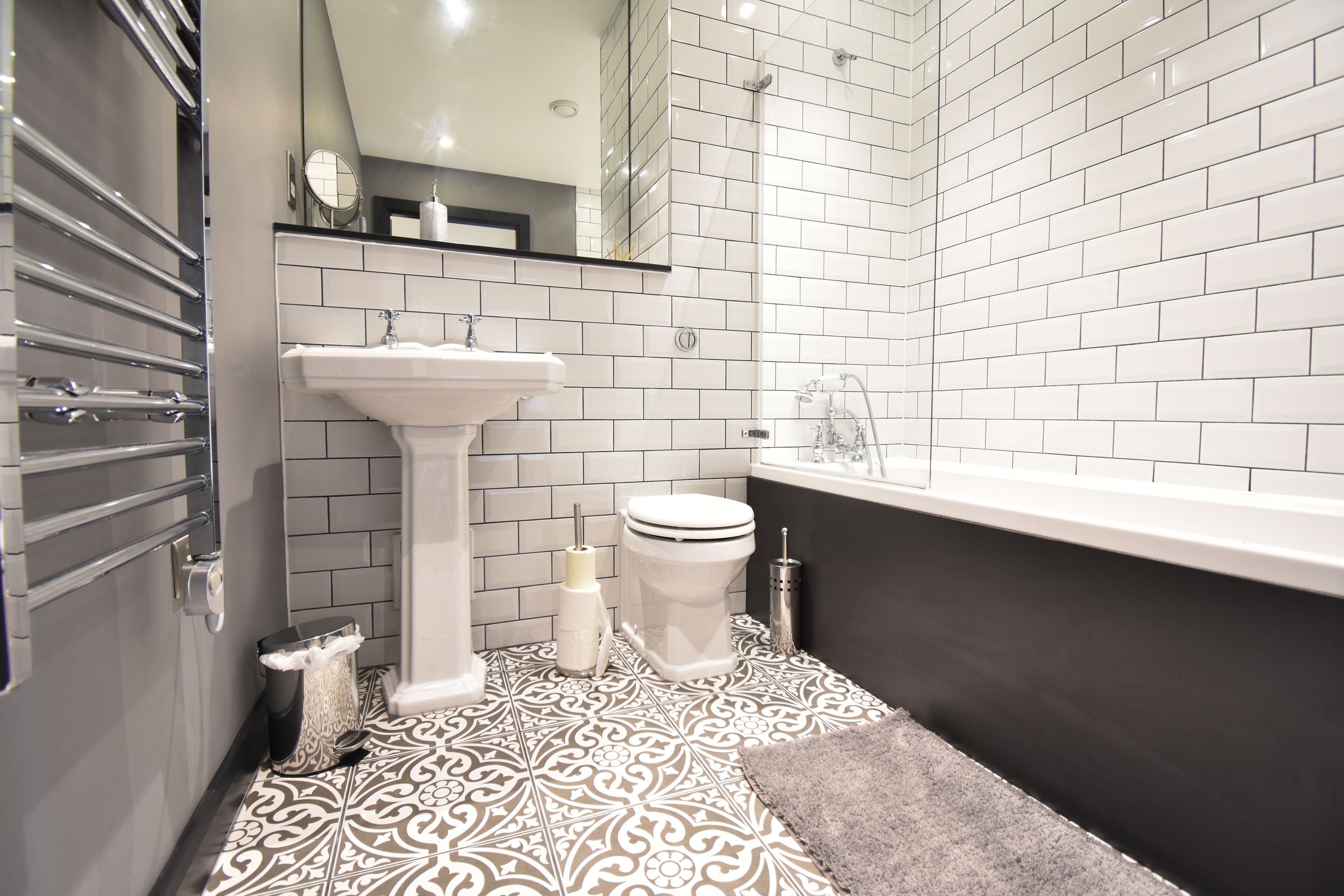 A modern bathroom with a white sink, toilet, and bathtub.