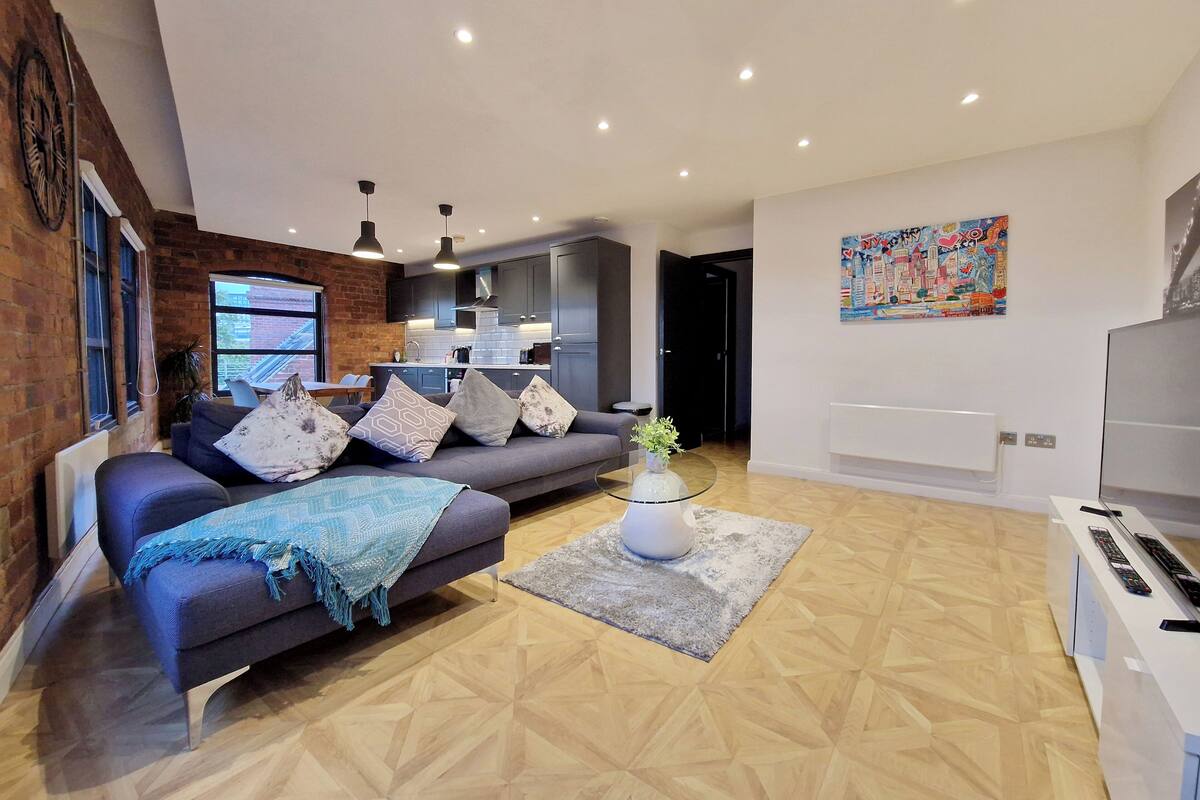 A modern living room with a sofa, coffee table, and a TV.