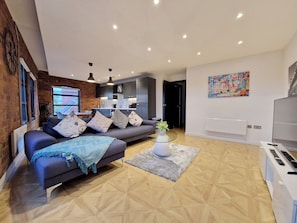 A modern living room with a sofa, coffee table, and a TV.
