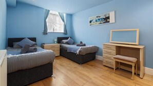 A bedroom with two beds, a desk, and a chair. - The Chandlery - Panoramic Sea Views With Parking (Saundersfoot)