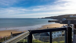 A coastal view with a beach, sea, and buildings in the background. - The Chandlery - Panoramic Sea Views With Parking (Saundersfoot)