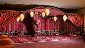 A stage with a patterned carpet, a sofa, and a chair. - Safwat Almiead Hotel (Makkah)