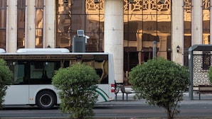 A building with a sign for Safwat Al-Miead Hotel, featuring a modern facade with large windows and a bus parked in front. - Safwat Almiead Hotel (Makkah)