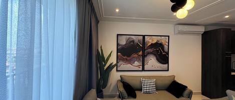 Un salon moderne avec un canapé, une table basse et des œuvres d’art accrochées au mur.