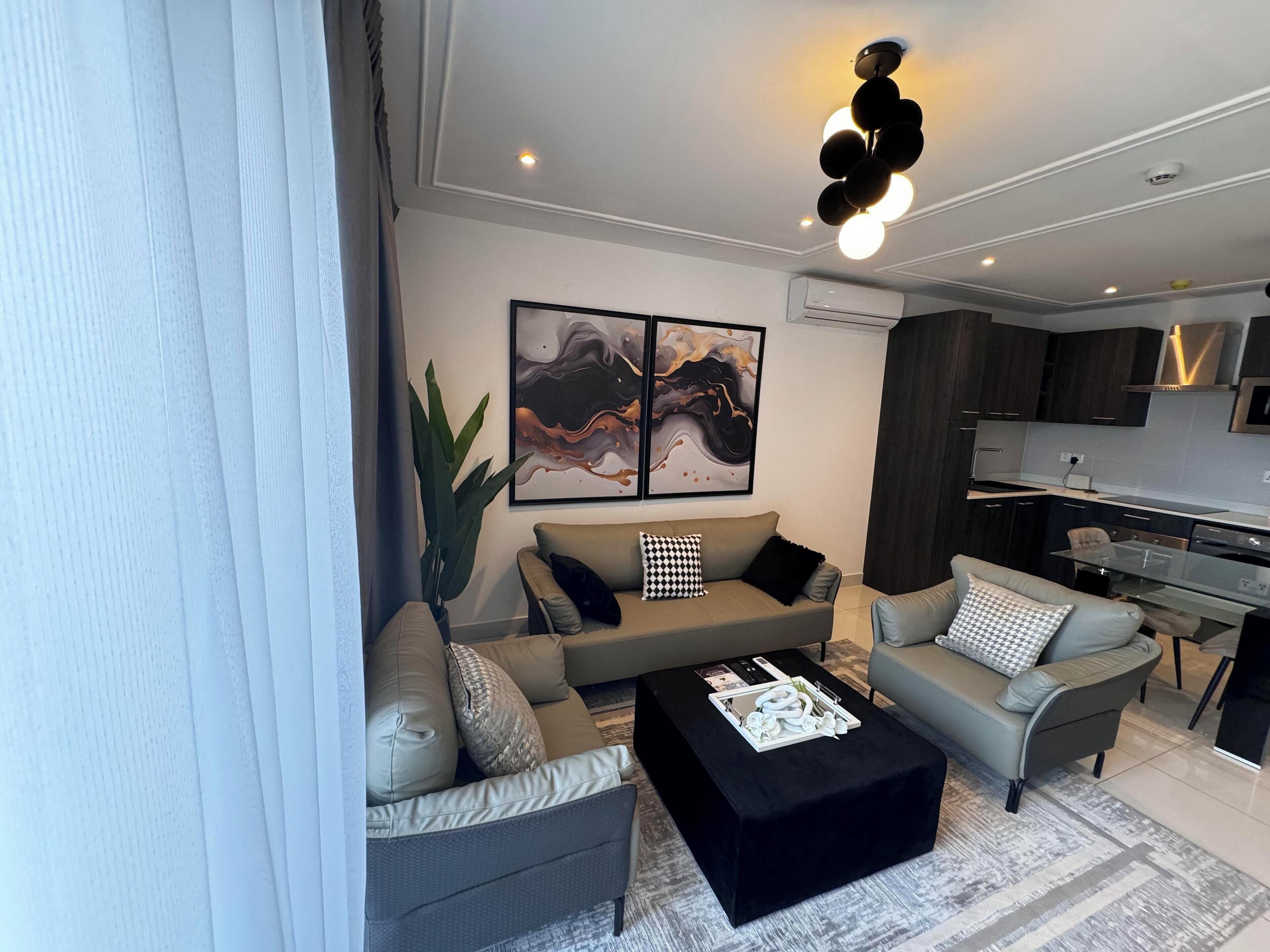 A modern living room with a sofa, coffee table, and artwork on the wall.