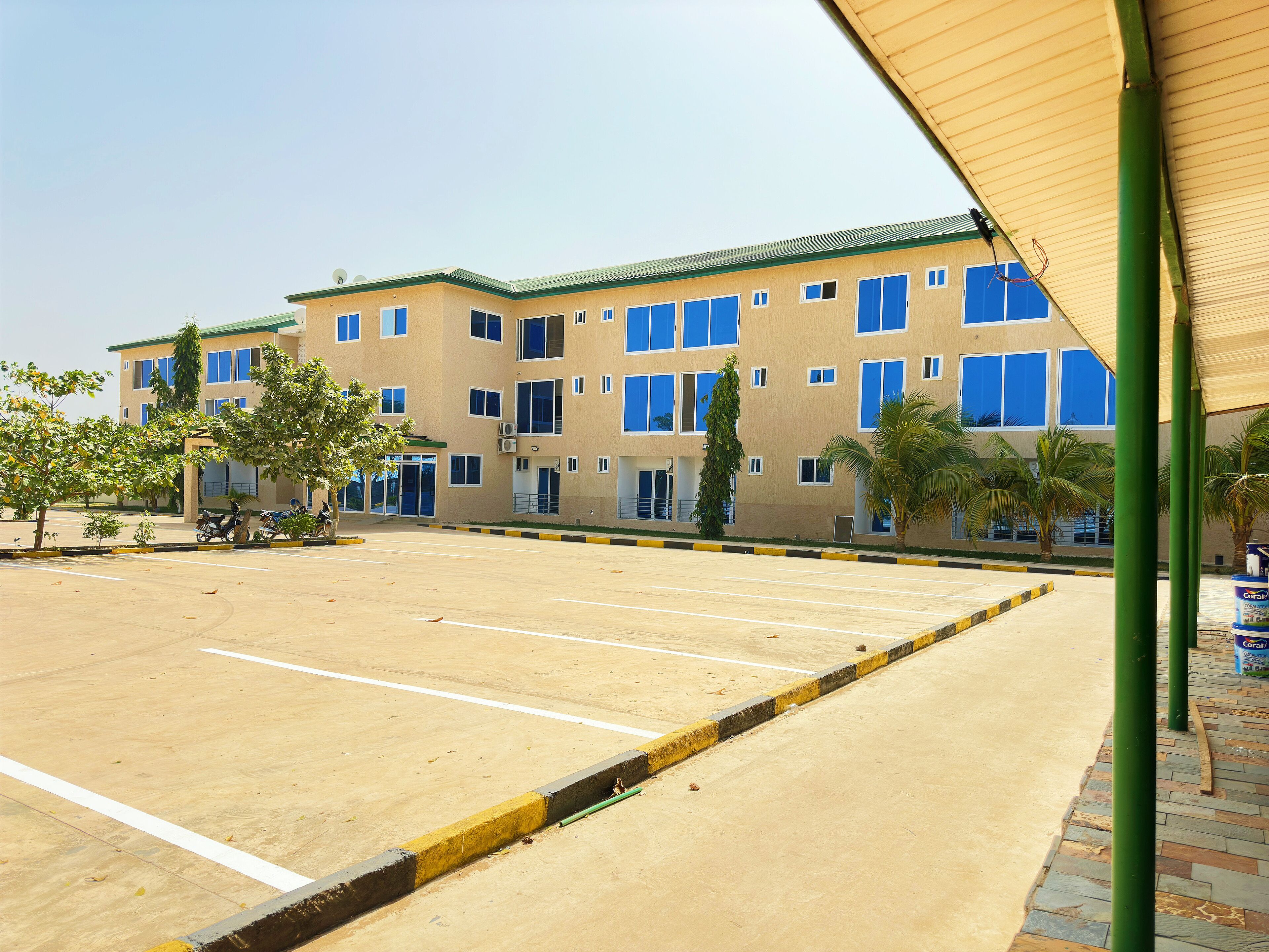 A multi-story building with a parking lot in front.