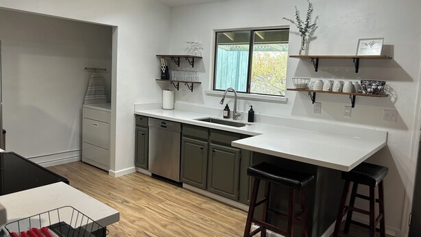 A modern kitchen with a central island, built-in appliances, and a window providing natural light. - Spacious Home + private suite with separate entrance. Family friendly! (Prescott)