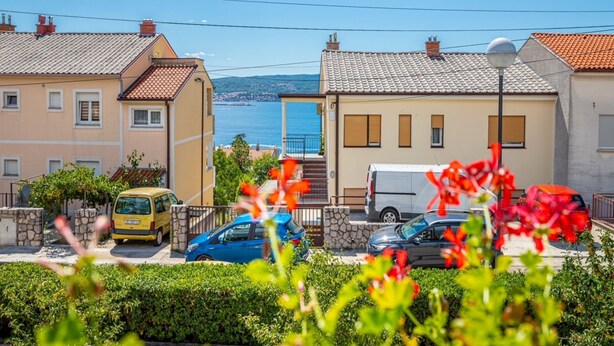 A coastal residential area with houses, a yellow taxi, and a blue car parked in front. - Modern Crikvenica Apartments With Sea View (Crikvenica)