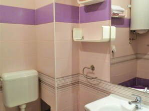 Une salle de bain avec des toilettes, un lavabo et un miroir.