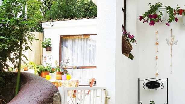 A small patio with a white gate, a table with chairs, potted plants, and a welcome sign. - Seafront Chic Crikvenica Apartments (Crikvenica)