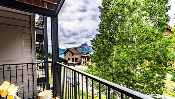 A balcony with a view of a mountain, a wooden deck, and a metal railing. - The Copper Bungalow (#110) | Walk to Purgatory Ski Lift - Deck, Fireplace (Durango)