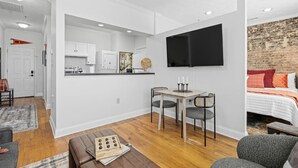 Un apartamento moderno con cocina, comedor y un dormitorio con pared de ladrillo.