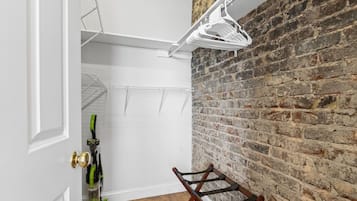 A room with a brick wall, a white door, and a wooden chair.
