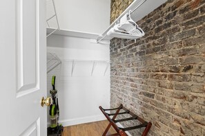 A room with a brick wall, a white door, and a wooden chair. - Scot's Suite - Downtown Maryville Loft (Maryville)