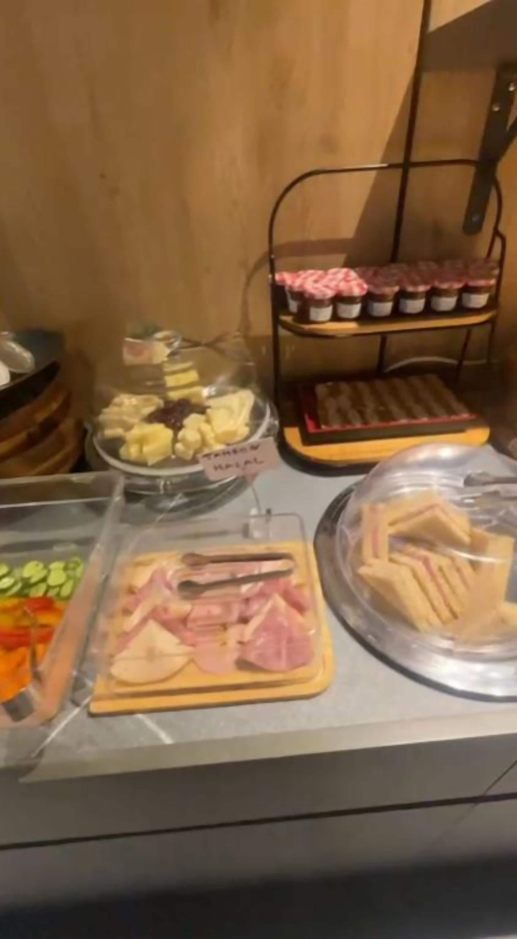 En buffé med ett varierat utbud av mat, inklusive frukt, kött och smörgåsar.