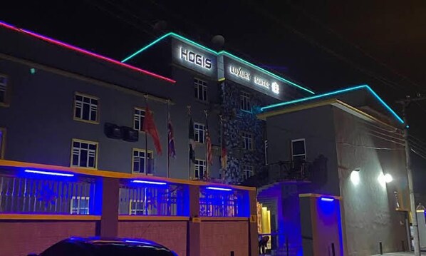 Un edificio con un letrero que dice "HOGIS LUXURY SUITES".
