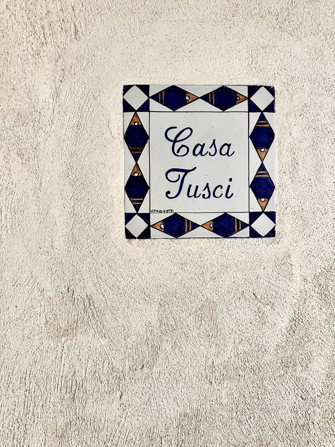 Un letrero con el texto 'Casa Tusci' en una pared texturizada.