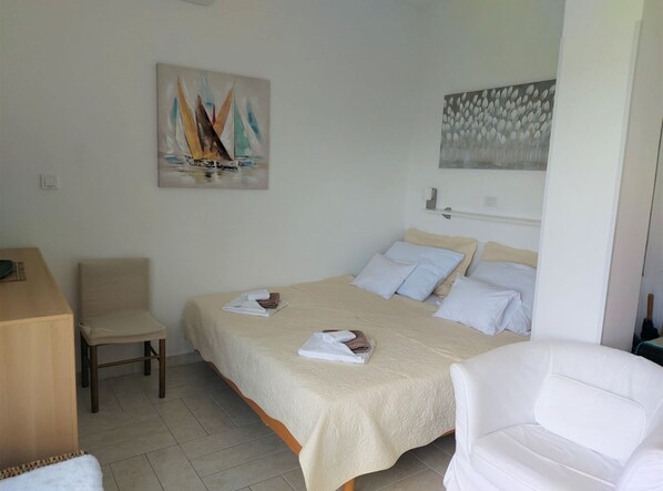 A bedroom with a bed, two chairs, a desk, and artwork on the walls. - Serene Crikvenica Holiday Home With Hot Tub (Crikvenica)
