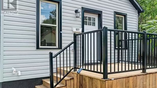 Una casa a un piano con un portico, una cassetta delle lettere e il numero '627' sulla parete.