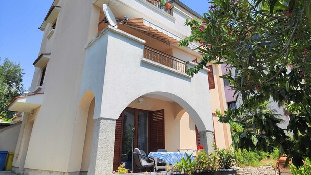 A two-story building with a balcony, an archway entrance, and potted plants. - Comfortable Crikvenica Stay With Private Parking (Crikvenica)