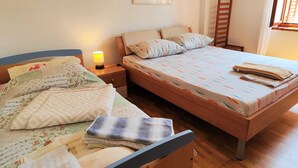 A bedroom with two beds, a nightstand with a lamp, a wooden ladder, and a framed picture on the wall. - Comfortable Crikvenica Stay With Private Parking (Crikvenica)